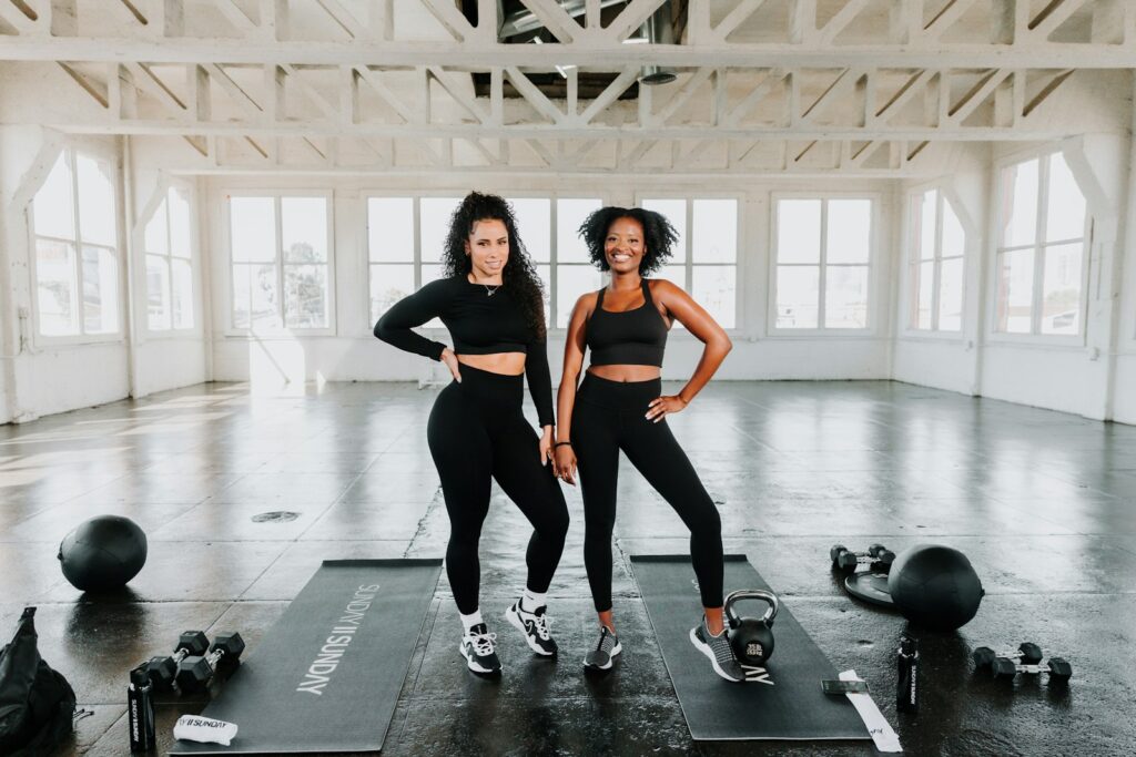 two women standing on exercise mats in a gym